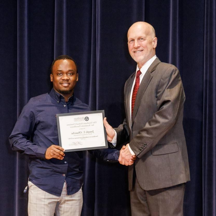 Joseph Ohaeche (right) receiving an award from Dr. Jeffrey Potteiger (left)